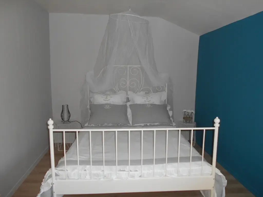 Chambre aux murs blancs avec lit à moustiquaire
